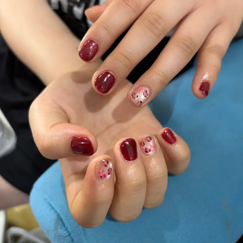 Burgundy nails with pink floral nail art by LENA Nails & Beauty, nail salon in Da Nang