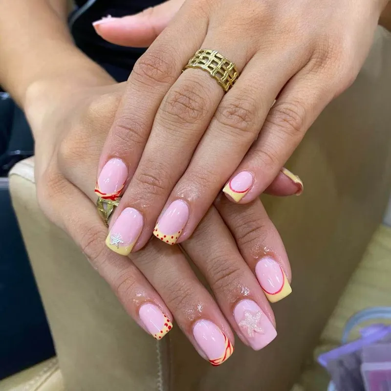 Pink square nails with yellow French tips and starfish by LENA Nails & Beauty, nail salon in Da Nang