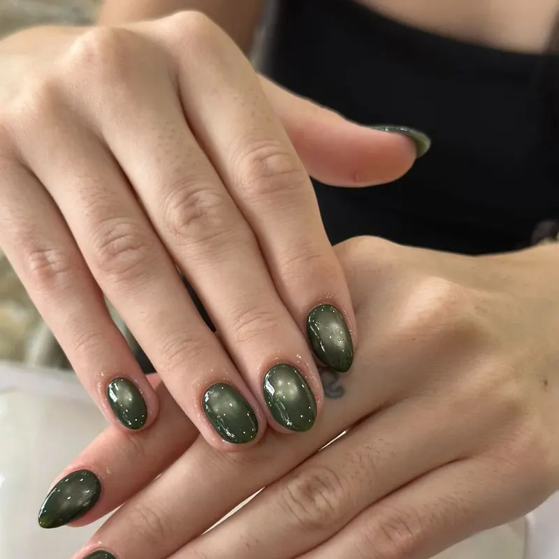 Dark green cat eye almond nails by LENA Nails & Beauty, nail salon in Da Nang