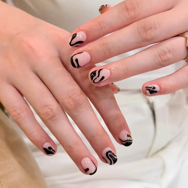 Nude nails with black abstract swirl art by LENA Nails & Beauty, nail salon in Da Nang