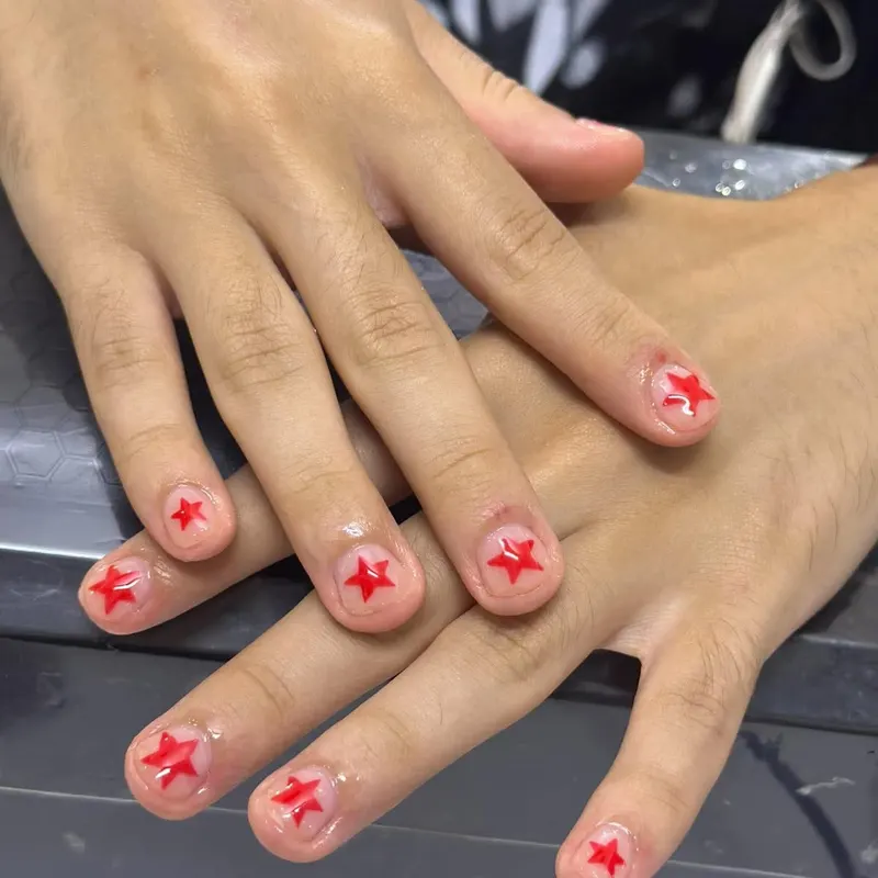 Short nude nails with red star art by LENA Nails & Beauty, nail salon in Da Nang
