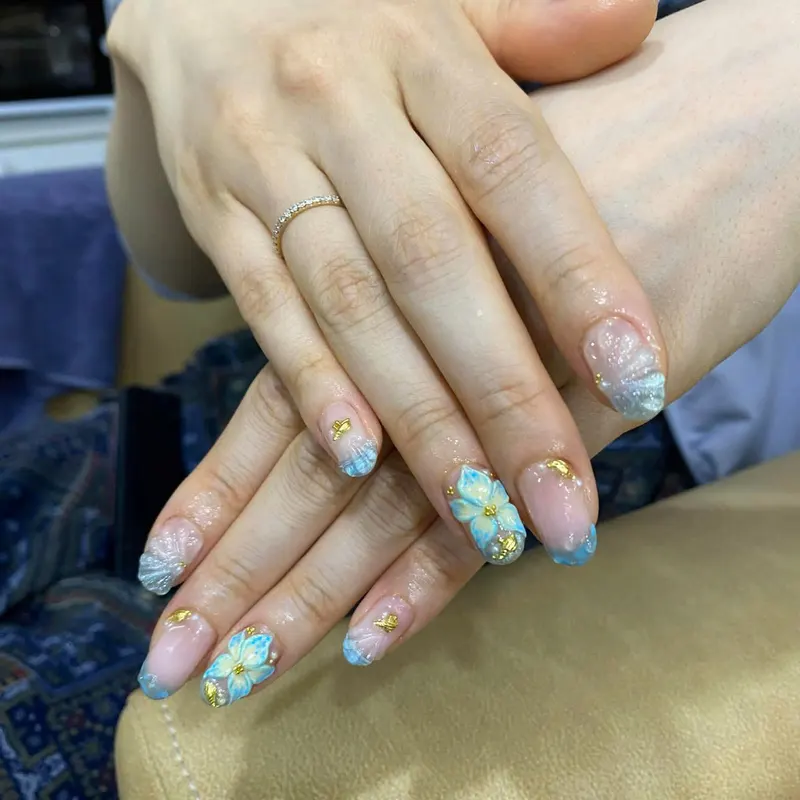 Blue nails with gold foil floral art by LENA Nails & Beauty, nail salon in Da Nang
