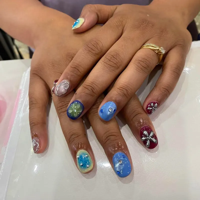 Short blue and burgundy nails with 3D flower art by LENA Nails & Beauty, nail salon in Da Nang