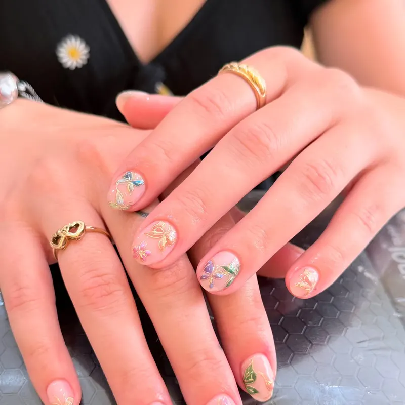 Short nude nails with mini flower and ribbon art by LENA Nails & Beauty, nail salon in Da Nang