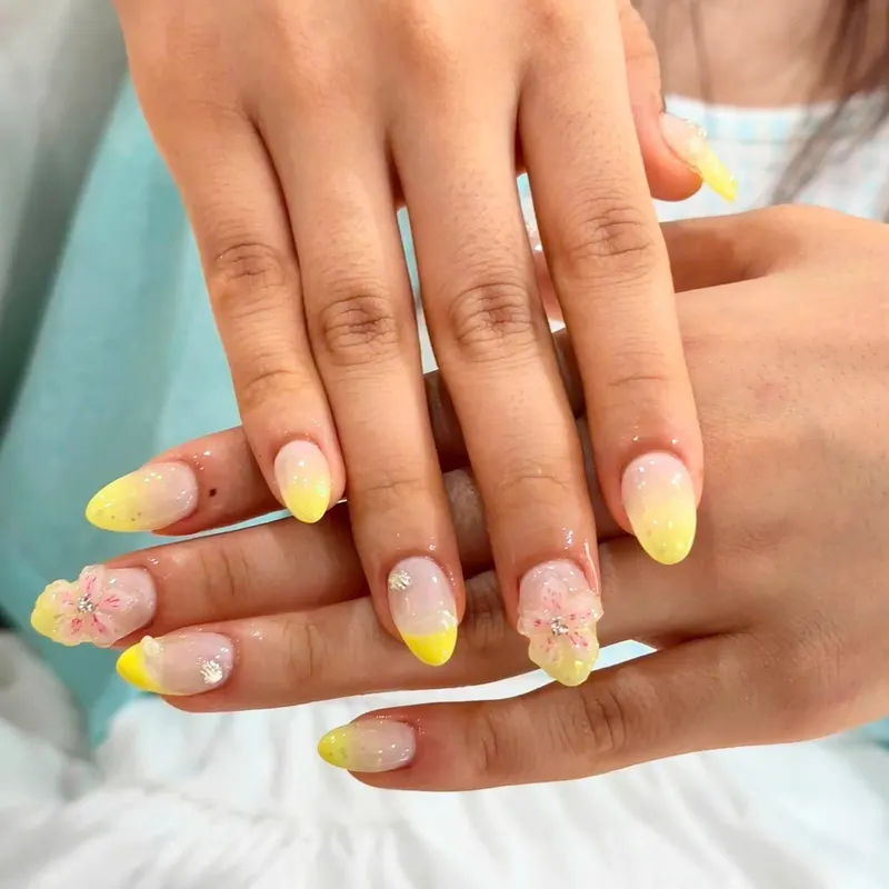 Nails with yellow tips and floral art by LENA Nails & Beauty, nail salon in Da Nang