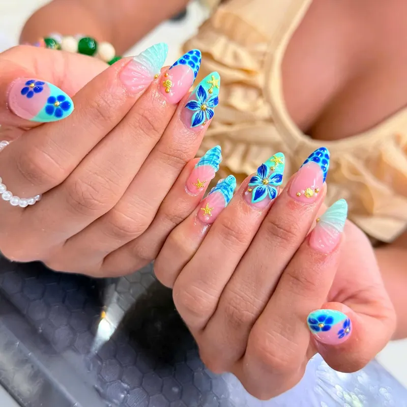 Pink stiletto nails with blue tropical flower art by LENA Nails & Beauty, nail salon in Da Nang