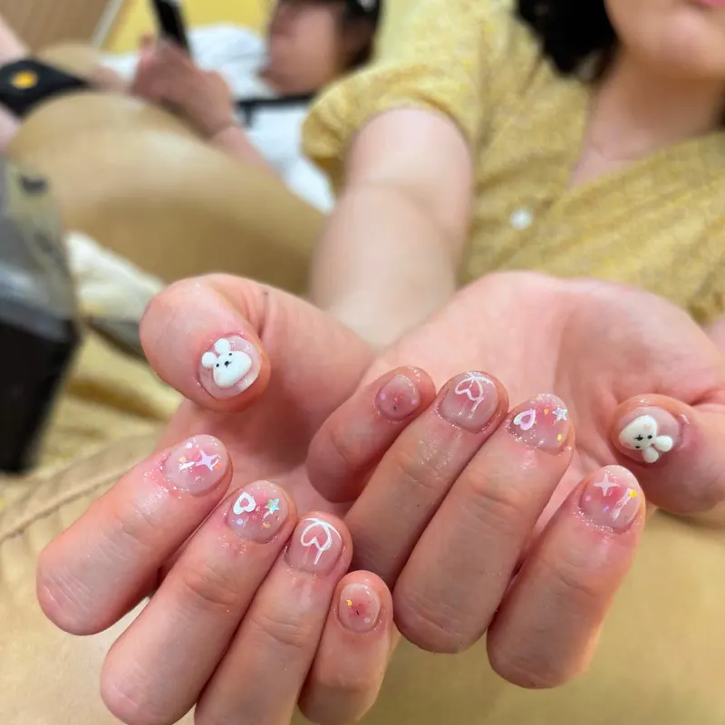 Milky nails with 3D bear charms and star art by LENA Nails & Beauty, nail salon in Da Nang