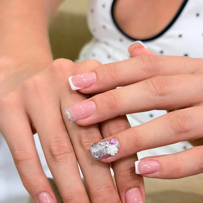 French nails with silver glitter and a 3D bow by LENA Nails & Beauty, nail salon in Da Nang