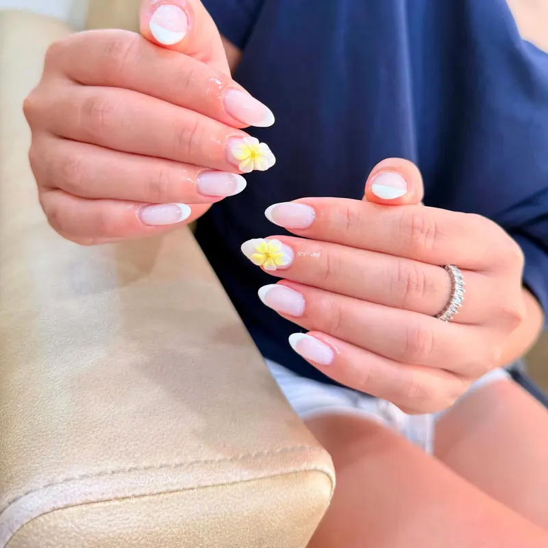 White nails with yellow flower art by LENA Nails & Beauty, nail salon in Da Nang